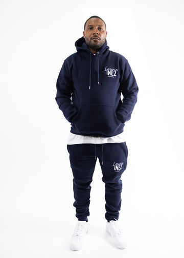 Person wearing a navy tracksuit with logo on a white background